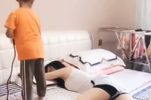 妈妈熟睡，儿子拿吹风机对着妈妈狂吹
