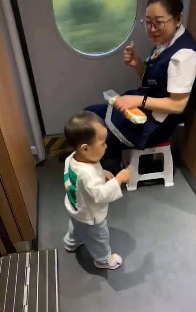 乘务员小姐姐给宝宝饼干吃,宝宝嘴上说不要,但身体却出卖了自己