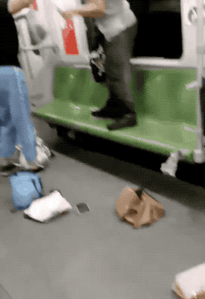 一对男女地铁里站椅子上打架,老人在一旁边吃饼干边看……(视频)