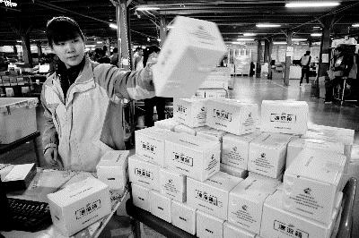 今天上午，苏宁工作人员在使用可循环利用的共享快递盒进行包装摄/记者 黑克