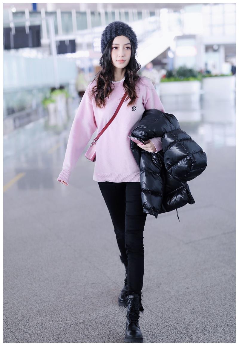Angelababy穿粉毛衣搭毛绒帽甜美可爱 手拿羽绒服大步前行